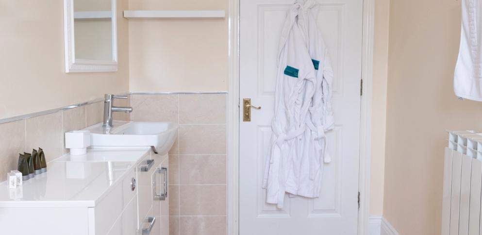 large bathroom with two dressing gown hung up on back of door