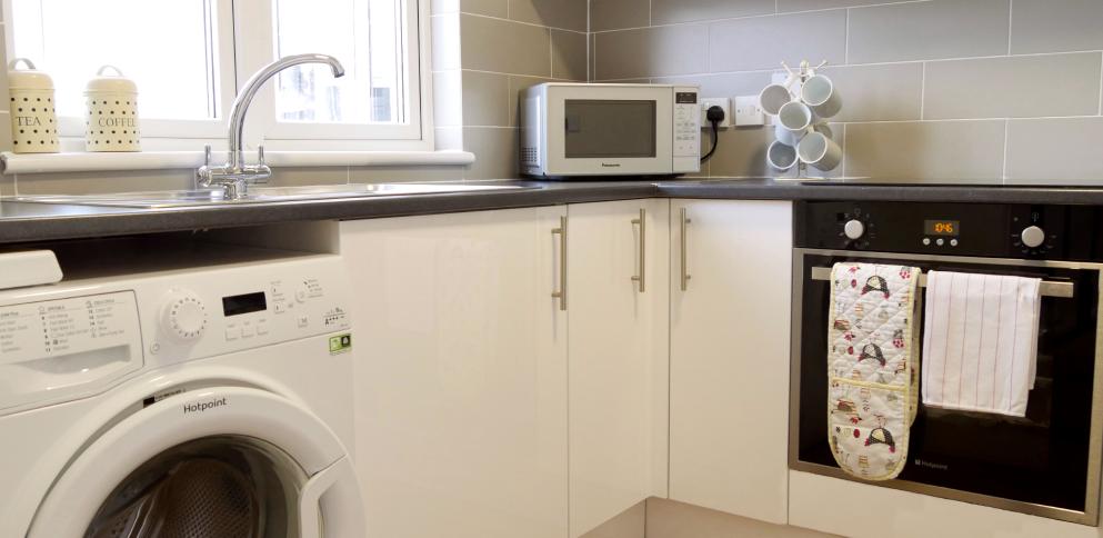 kitchen with white cabinets and sleek black worktop