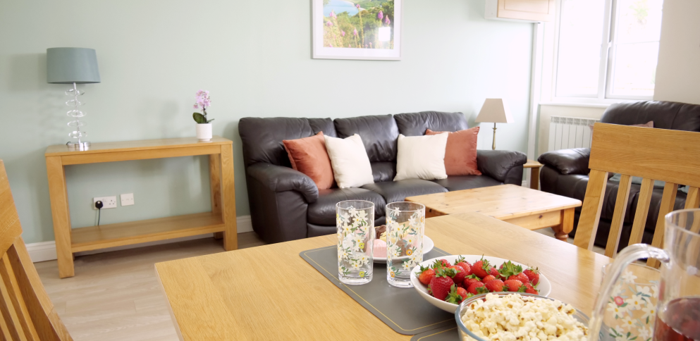 living room with table set with snacks and a sofa in the background