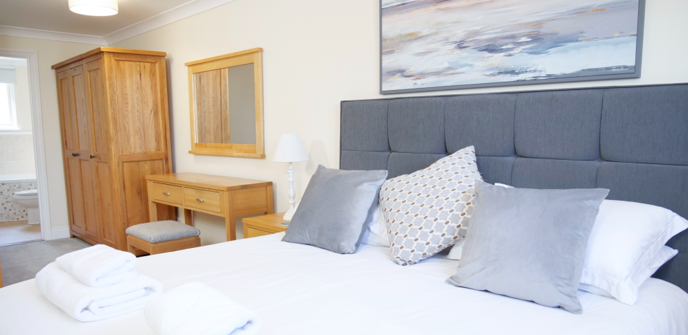 Master bedroom with en-suite. Grey divan bed and oak furniture