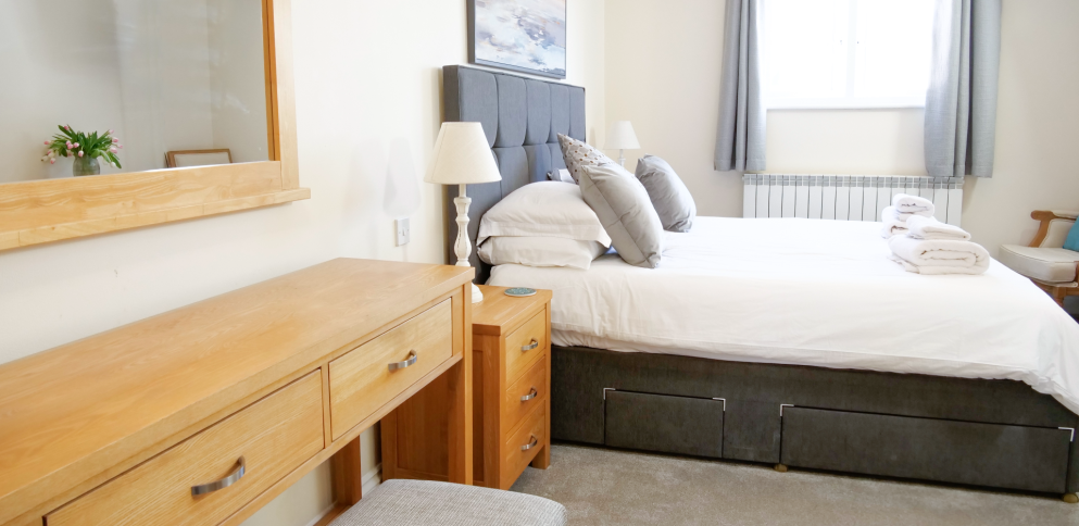 Master bedroom withg rey divan bed and oak dressing table