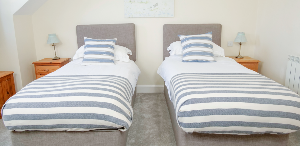 twin beds in large room with a coastal theme