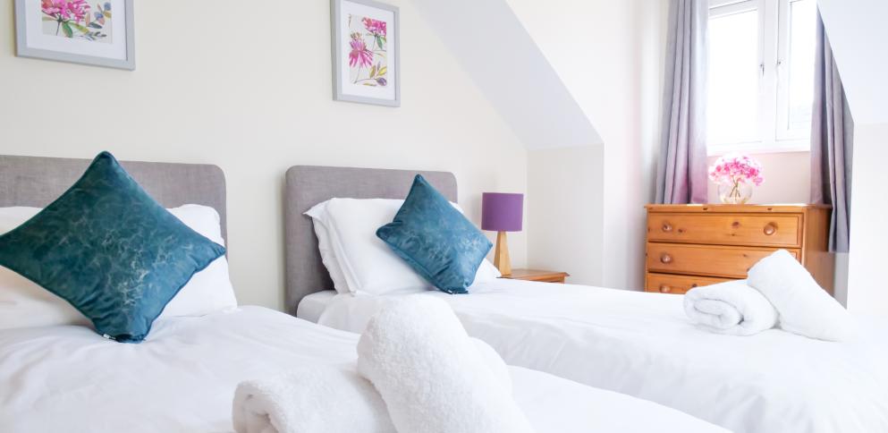 bedroom with two single beds and a teal cushion