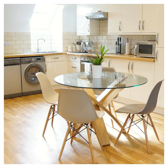 glass dining table with kitchen in background